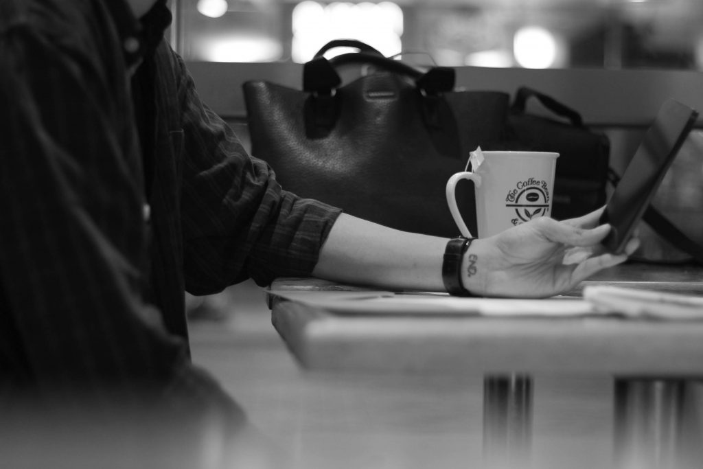 Guy using phone in cafe