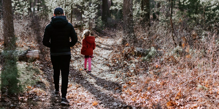 Father and daughter walking around the forest