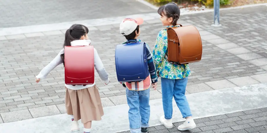 Japanese school children heading to school with wearing their Randoseri