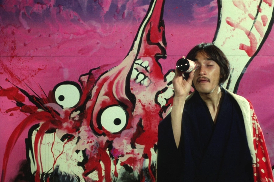 an experimental japanese artist in front of his work