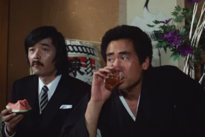 Two Japanese men drinking umeshu plum liqueur in a traditional setting representing Japanese drinking culture and the popular sweet plum alcohol beverage.