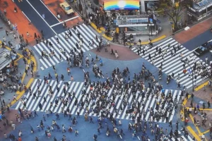 Crowds of pedestrians crossing Shibuya Crossing in Tokyo one of the busiest intersections in Japan highlighting urban population trends and demographic challenges.