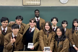 International exchange students in Japanese high school uniforms posing in a classroom during a study abroad program in Japan