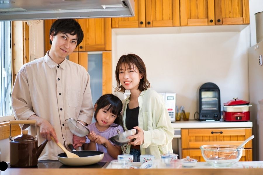 A family cooking a meal in a functional Japanese kitchen