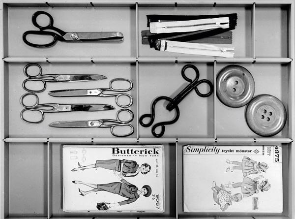 A neatly organized sewing kit with scissors, zippers, buttons, and vintage sewing patterns, reflecting Japanese and Danish design simplicity. A neatly organized sewing kit with scissors, zippers, buttons, and vintage sewing patterns, reflecting Japanese and Danish design simplicity.
