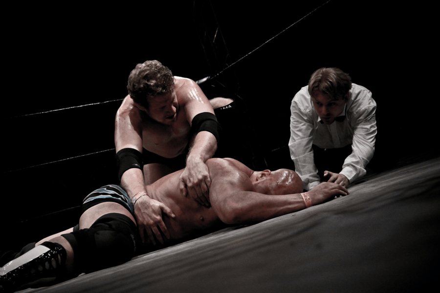 a wrestler pinning his opponent with the ref counting down