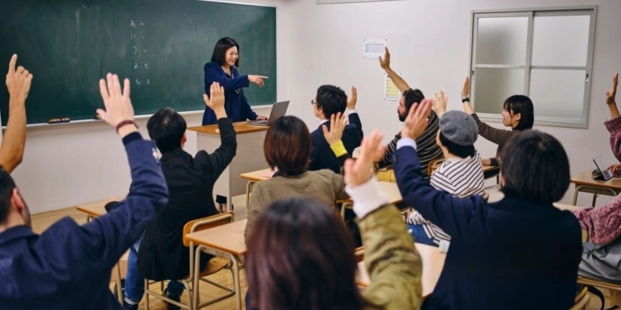 Students raising their hands with a female teacher