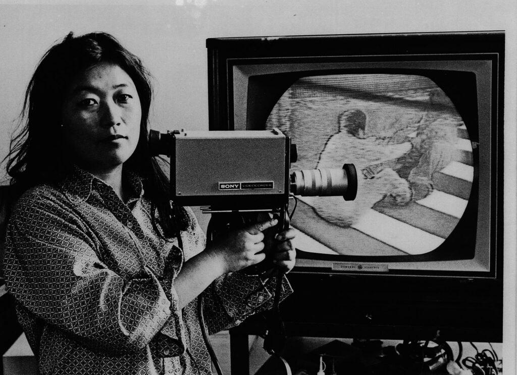Shigeko Kubota holding a Sony Portapak Camera Shigeko Kubota holding a Sony Portapak Camera.