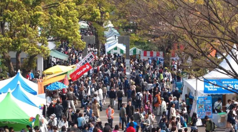 A large crowd goes through a big street that consists of the Earth Day Market