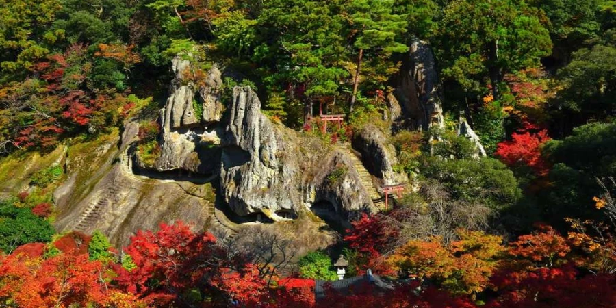A mixture of red, green, and orange leaves surrounding the temple