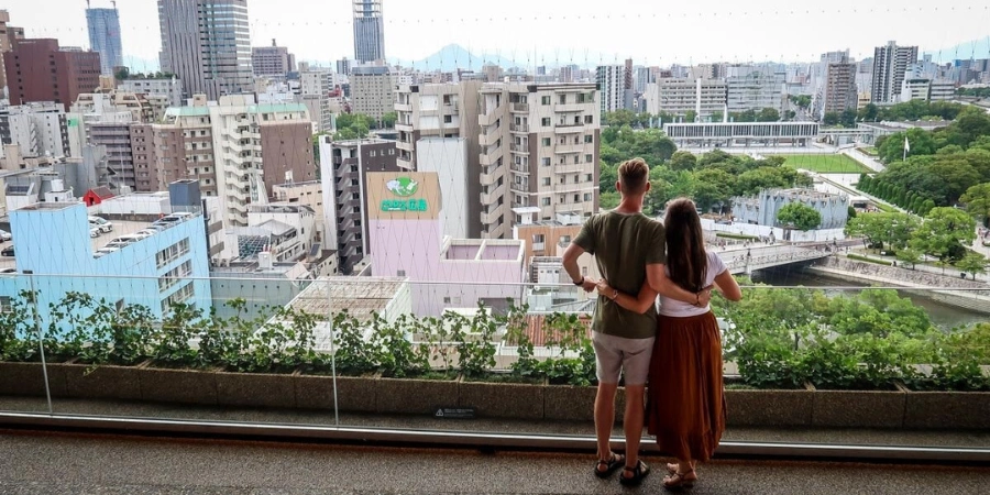 A man and a woman standing together at the Hiroshima Orizuru Tower
