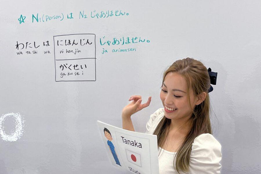 A Japanese instructor videos herself teaching Japanese phrases to her students who are watching her via Zoom.