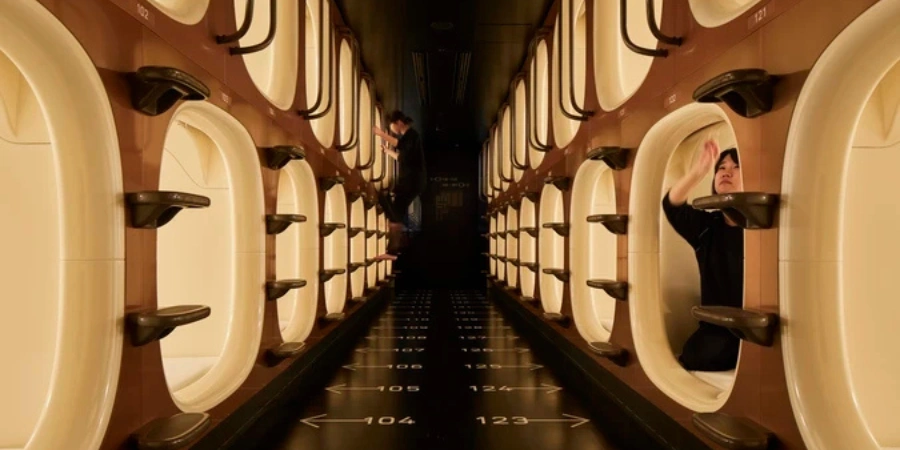 A person inside a capsule in a capsule hotel in Japan