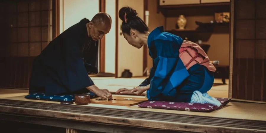 A man and a woman playing a game of go/shogi (chess)