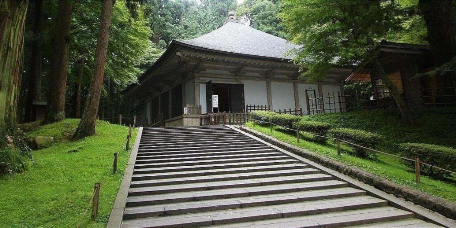 An isolated temple with lush green grass and trees