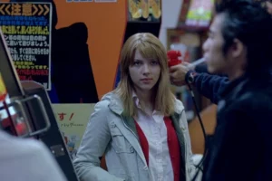 scene from lost in translation showing young woman in tokyo arcade reflecting themes of isolation connection and japanese urban culture in film.