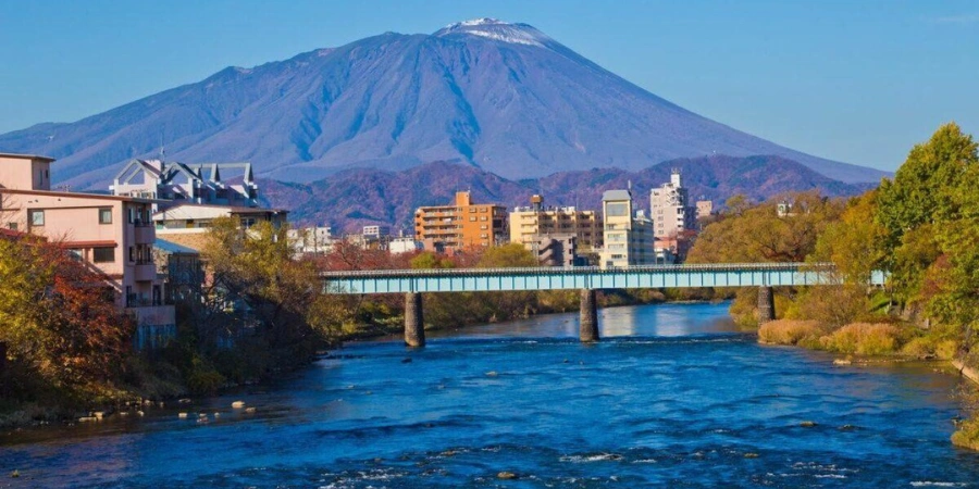 A mountain and a few buildings with a bridge (Morioka)