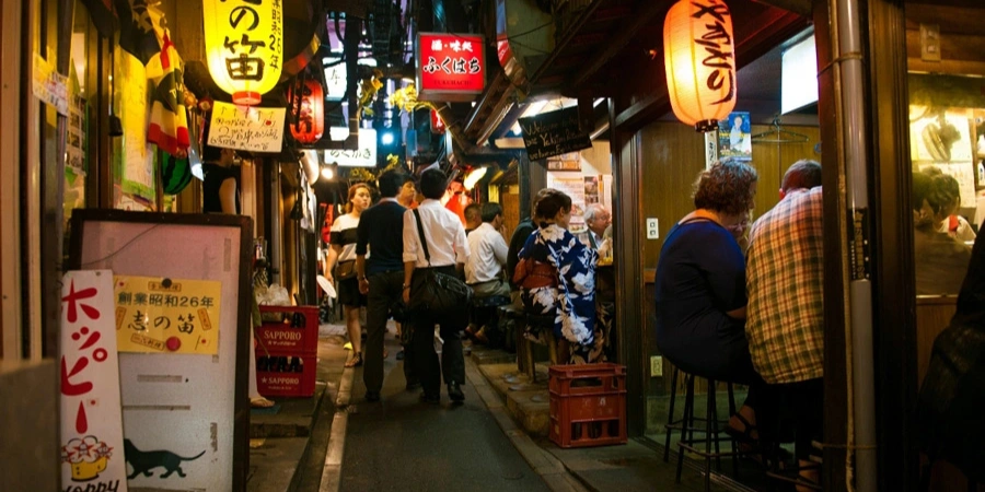 People walking and eating along the restaurants in an alley