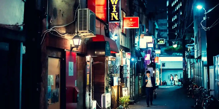 A man walking down the street alone in the night