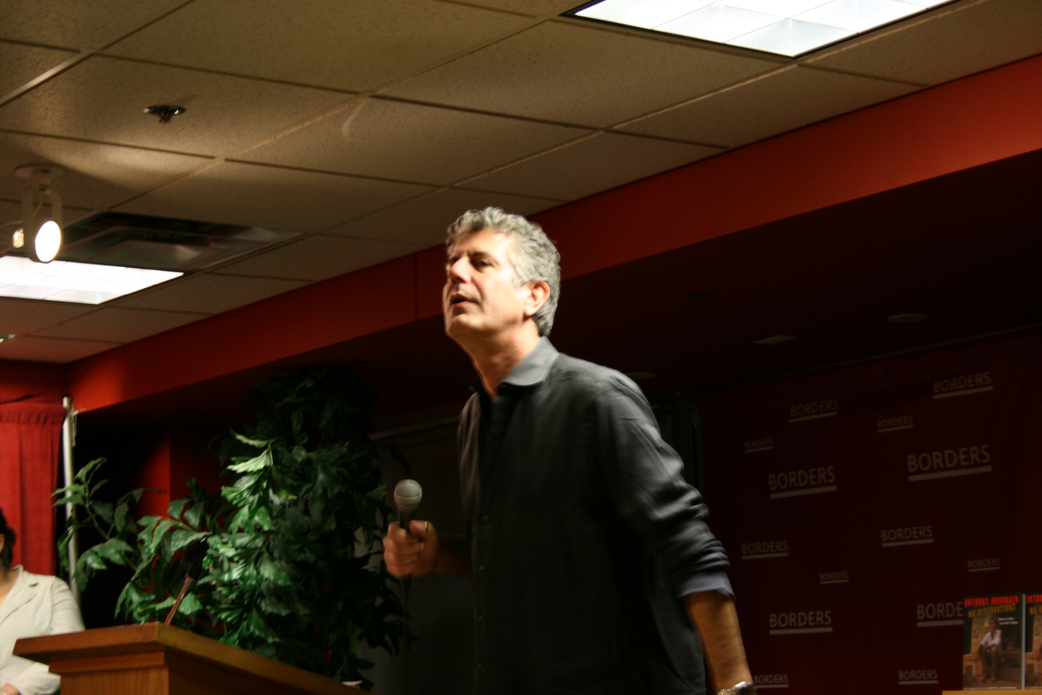 Anthony Bourdain speaking into a microphone at a Borders bookshop event