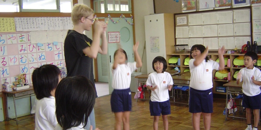 A teacher playing with kids the "Head, Shoulders, Knees, and Toes" song