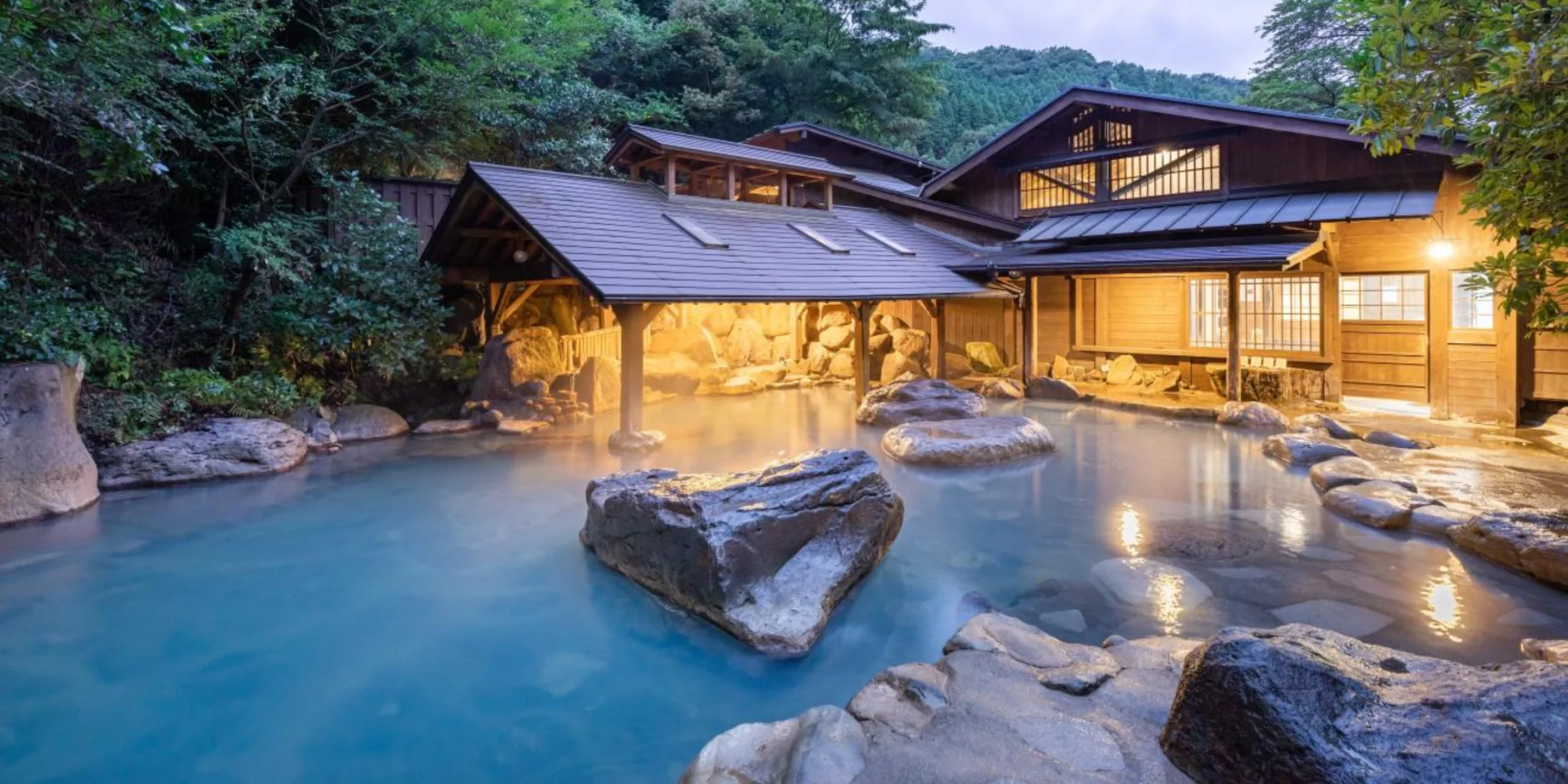 A Kurokawa onsen next to a roofed structure and some greenery