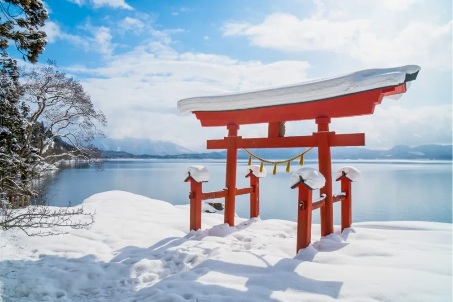 Red Japanese Torii gate of Goza no Ishi Shrine, Lake Tazawa in winter