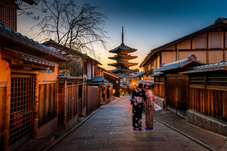 two women in purple and pink kimono standing on the streets of Gion in Kyoto