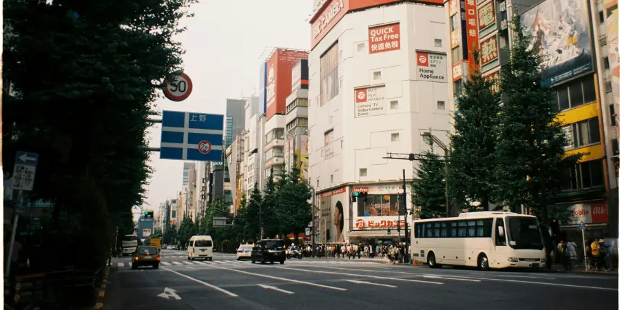 Wide road lined with shops and a bus near Akihabara on the edge of Taito City