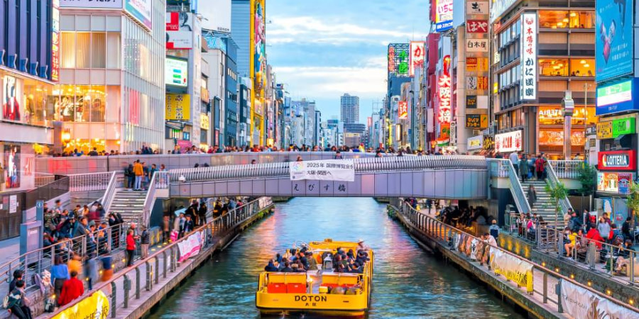 Yellow ferry passing through the river in Dotonbori, Osaka