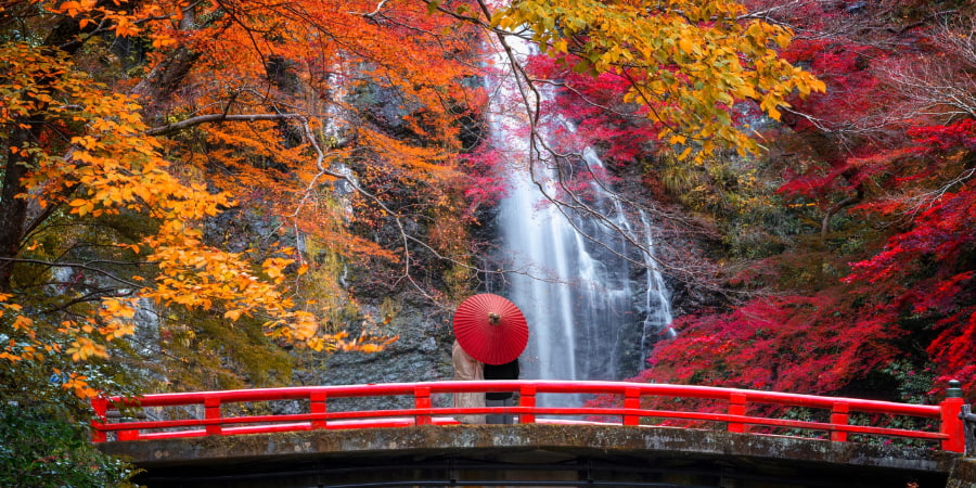 Red bridge against the autumn foliage in Minoh Falls 