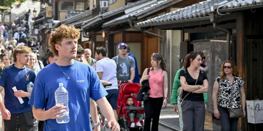 A foreigner man walking in Japan with so many people around him