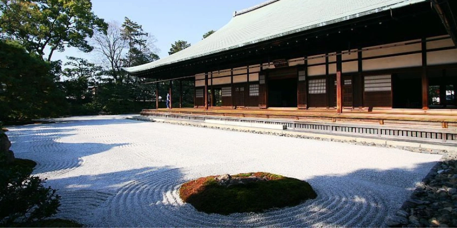 The traditional architecture of the Kenninji Temple features tatami mat flooring, wooden beams, and shoji sliding doors, creating a serene and minimalist atmosphere characteristic of Zen aesthetics. The black-and-white dragon painting on the fusuma (sliding doors) is a notable element, reflecting the temple’s strong ties to Zen Buddhism. The open-air design allows natural light to filter in.