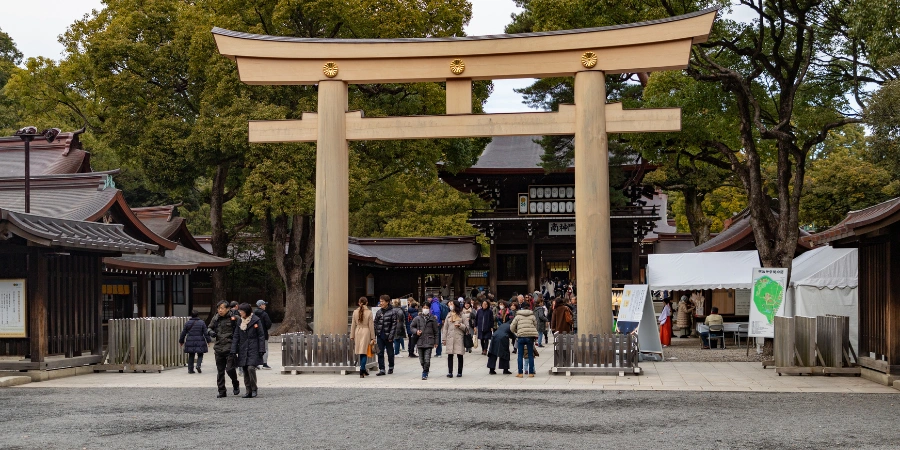 people gather at Meiji Jingu shrine beneath the tori gate