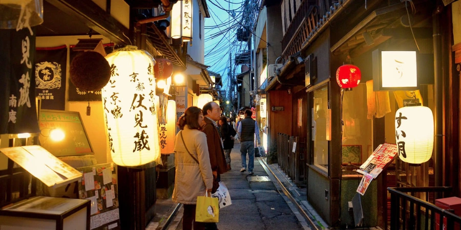 This image shows a traditional Japanese eatery in Kyoto’s Pontocho Alley. The soft glow of the paper lantern, the noren curtain, and the glimpse of a patron inside create a cozy and inviting scene.
