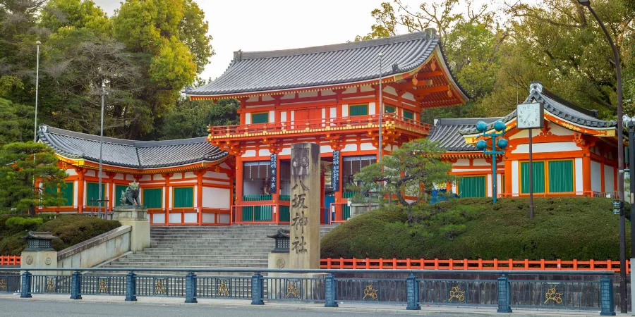 The Yasaka Shrine that showcases traditional Shinto architecture, featuring vibrant vermillion and white colors, intricate wooden carvings, and a sweeping roof with elegant eaves.