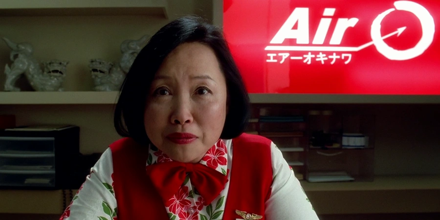 Woman working at the desk in front of The Bride, Flying a Japanese Airlines in Kill Bill.