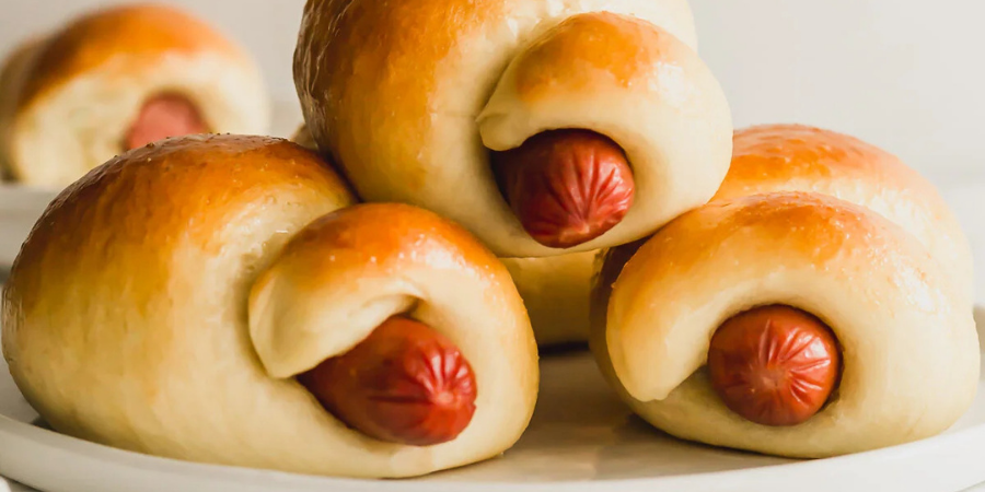 Hotdog rolls plated with a white background
