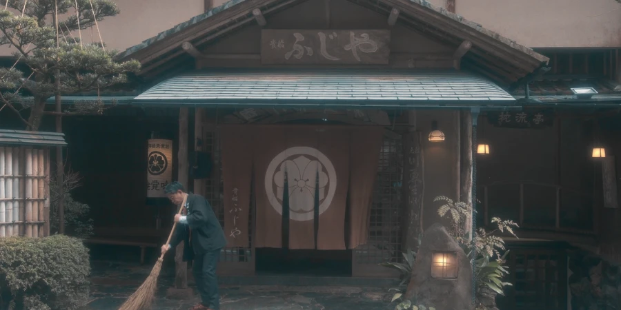 A staff cleaning outside the entrance of the ryokan