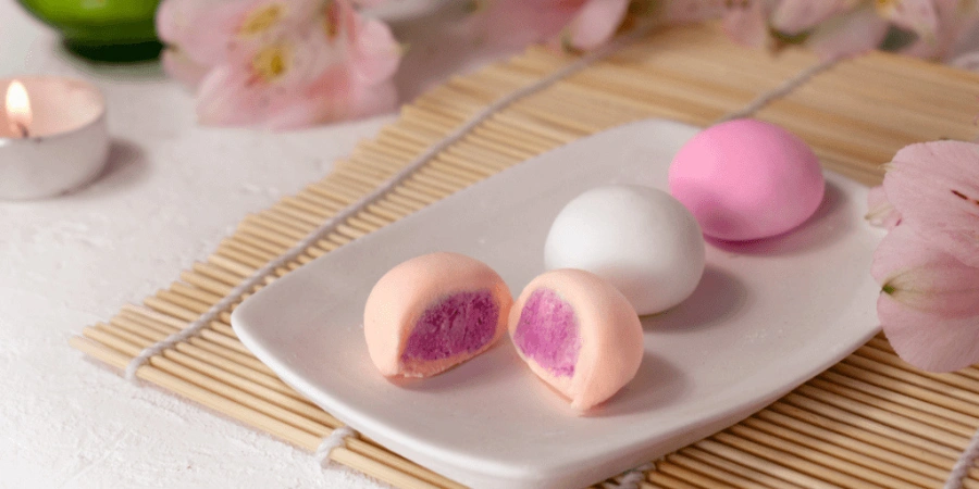 A plate of pink daifuku, also known as stuffed rice cakes.