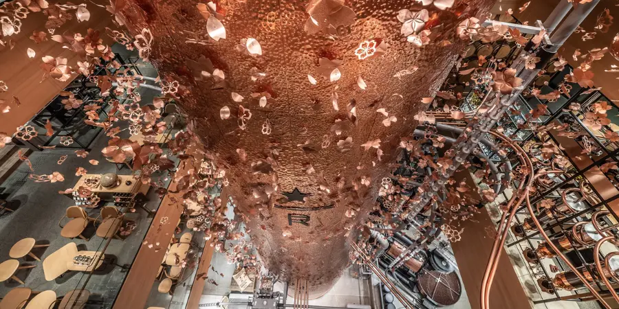 Interior of the starbucks reserve roastery in tokyo, featuring a large copper cask