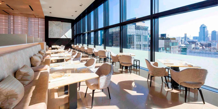 Interior of the Chanel restaurant in Tokyo, with tables and chairs overlooking a panoramic view