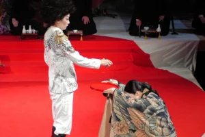 A women offering a red plate to the man