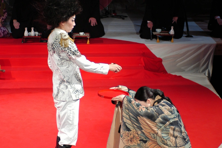 A women offering a red plate to the man