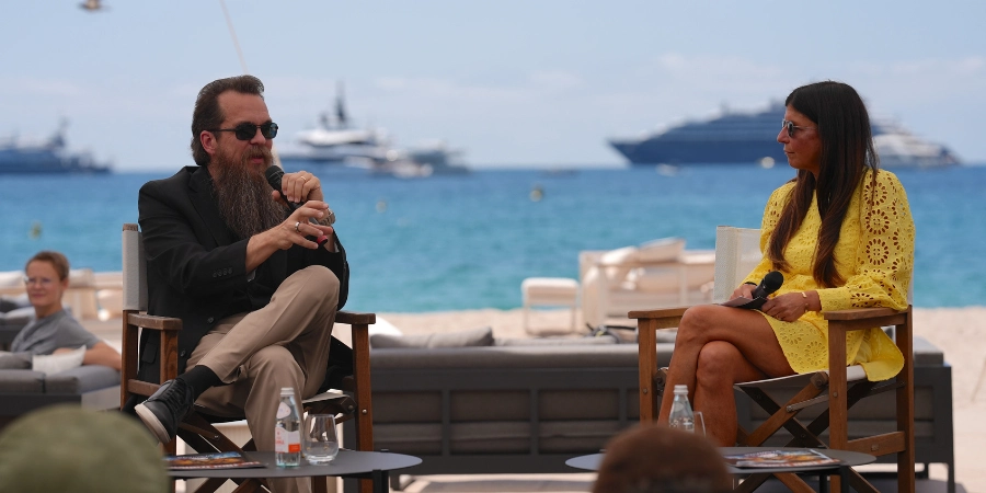 A man and a woman talking about a topic in front of the audience