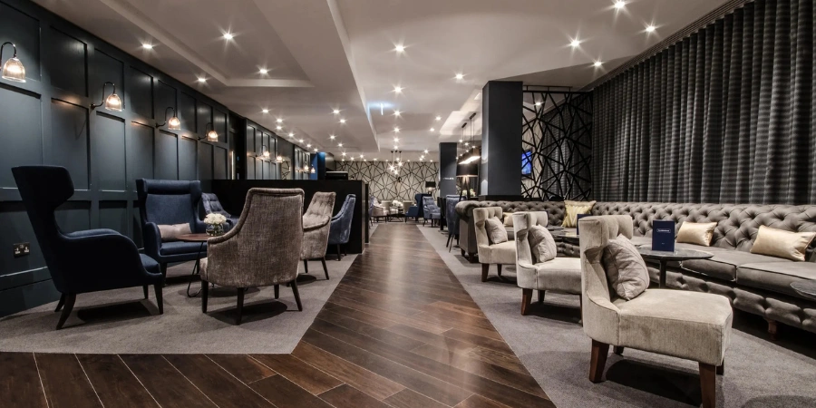 The cozy interior of Gatwick North Lounge at the Gatwick Airport. The color palette mainly consists of beige, brown, and black.
