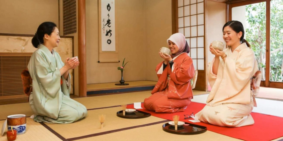 Three women doing tea ceremony in a Japanese style room
