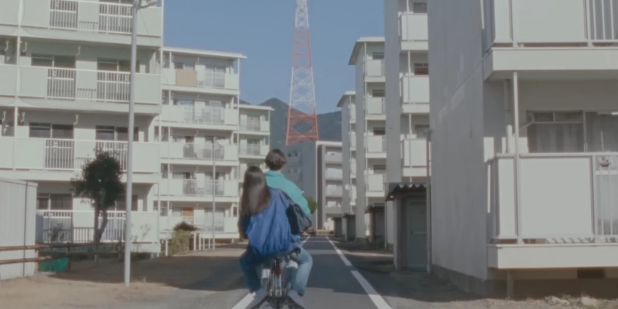 a couple riding a bike in a small suburb of Japan