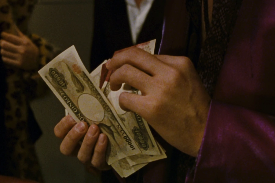 A person holding and counting Japanese Yen money