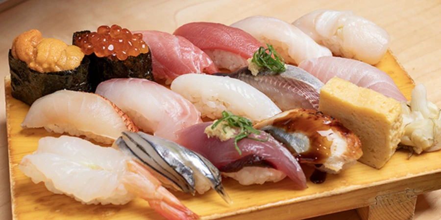16 pieces of sushi on a wooden tray